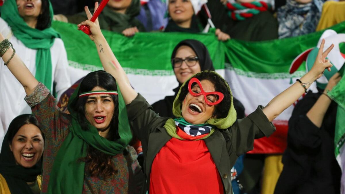 Iranian women cheer during the World Cup Qatar 2022 Group C qualification football match between Iran and Cambodia at the Azadi stadium in the capital Tehran on October 10, 2019. ATTA KENARE / AFP