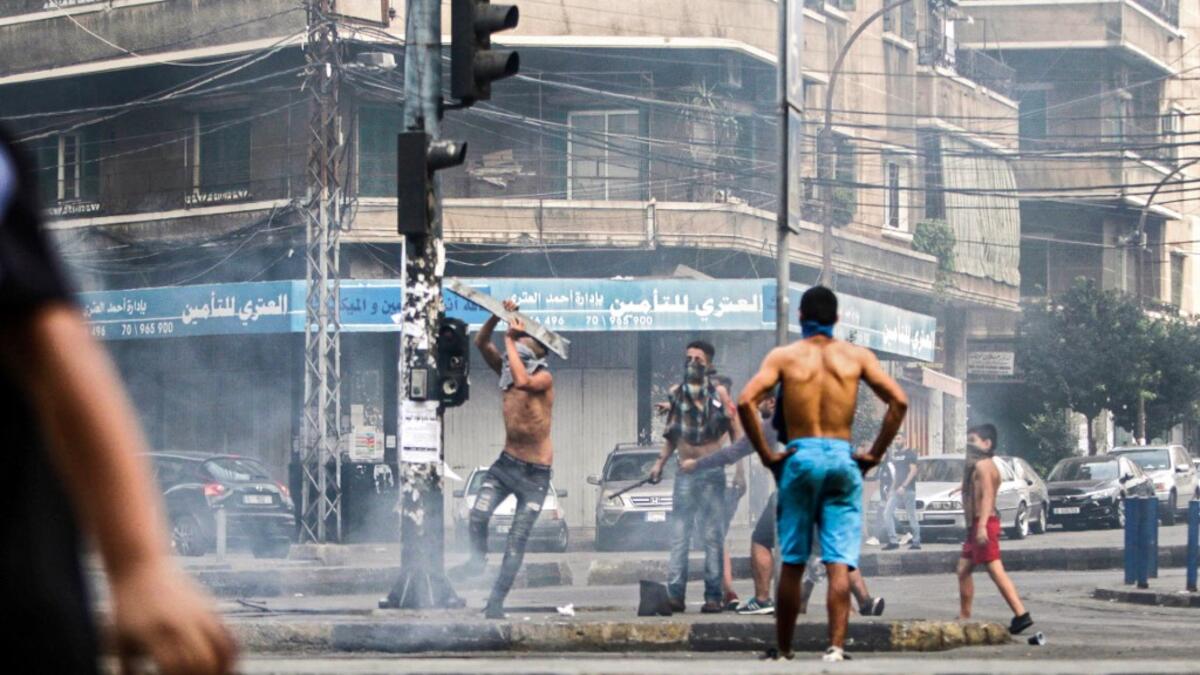 Lebanese demonstrators break traffic lights amidst ongoing protests against dire economic conditions in the northern coastal city of Tripoli on October 18, 2019. Ibrahim CHALHOUB / AFP