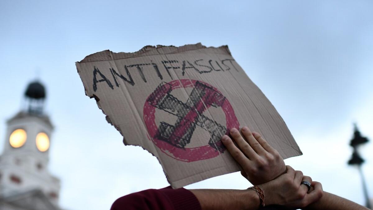 A protester holds up a sign with an anti-fascist symbol during a pro-amnesty demonstration called by Madrid's Anti-repression Movement and demanding total amnesty and the defence of democratic rights and freedoms in Madrid on October 19, 2019. OSCAR DEL POZO / AFP