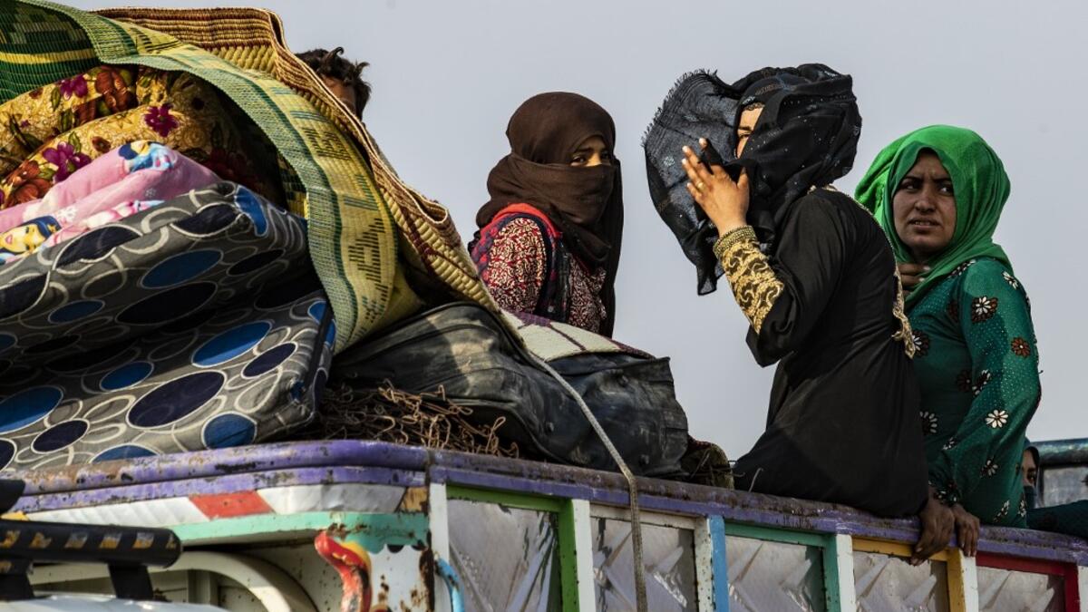 Syrians flee with their belongings the countryside of the northeastern Syrian town of Ras al-Ain on the Turkish border, toward the west to the town of Tal Tamr on October 19, 2019. Turkey's President Recep Tayyip Erdogan fired off a fresh warning today to "crush" Kurdish forces as both sides traded accusations of violating a US-brokered truce deal in northeastern Syria. Delil SOULEIMAN / AFP