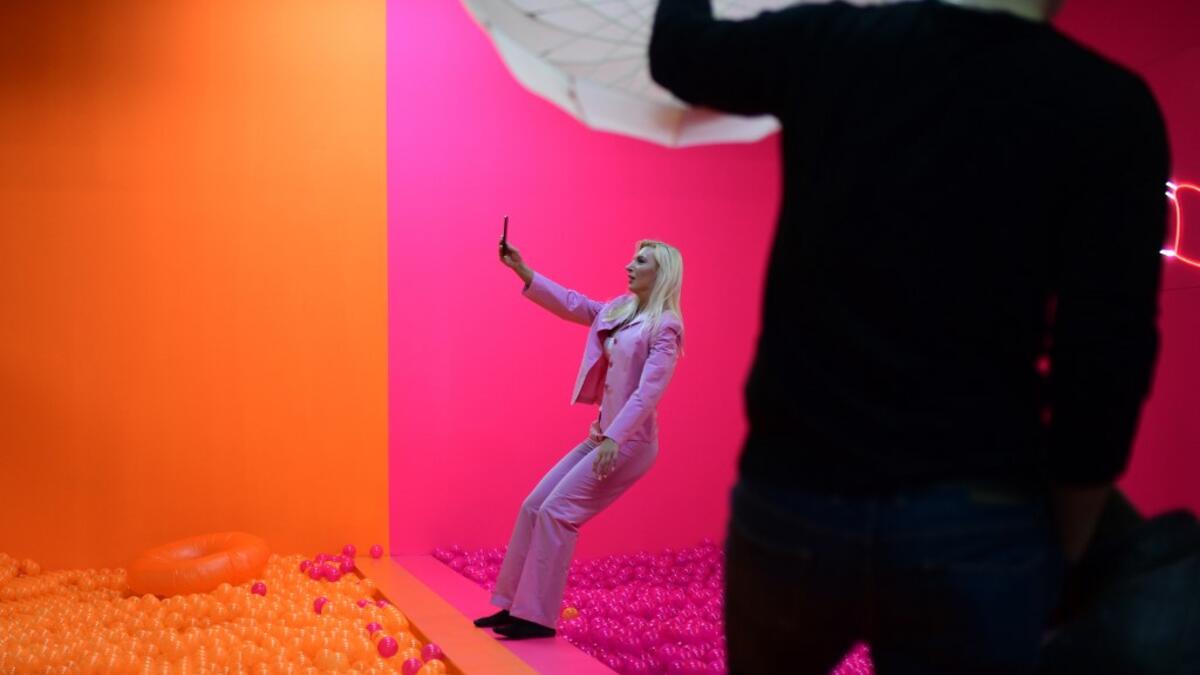 A woman photographs herself as she falls into a ball bath at the "Supercandy Pop-Up Museum Vol. 2" in Cologne, western Germany on November 1, 2019. It is an interactive museum and offers a photo backdrop for social media at 25 stations. INA FASSBENDER / AFP