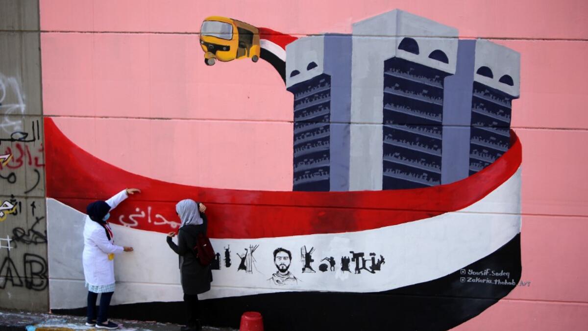 Iraqi demonstrators rest in front of a mural painting in Tahrir square during ongoing anti-government demonstrations in the capital Baghdad on November 2, 2019. The demonstrations have evolved since October 1 from rage over corruption and unemployment to demands for a total government overhaul, shunning both politicians and religious figures along the way. SABAH ARAR / AFP