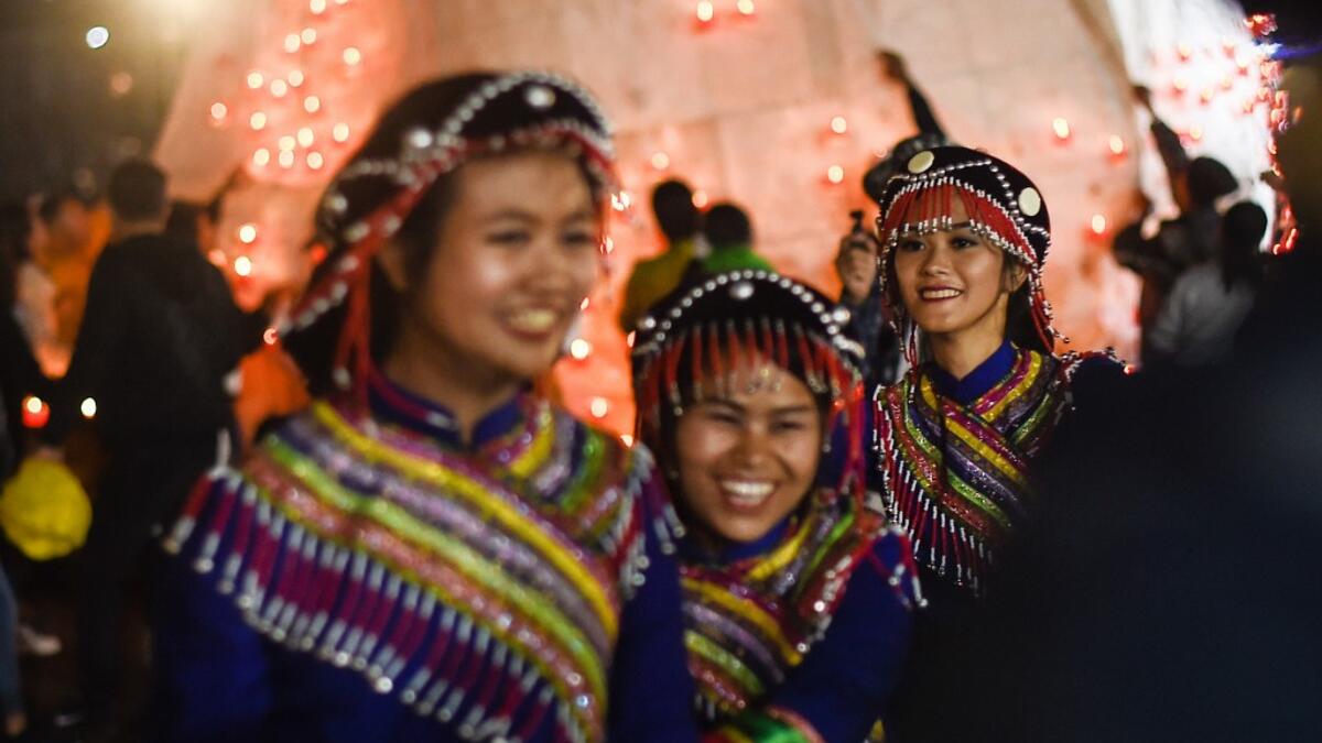 This picture taken on November 4, 2019 shows Wa ethnic women smiling during the Tazaungdaing Lighting Festival at Taunggyi in Myanmar's northeastern Shan State. Brightly coloured balloons with hundreds of homemade fireworks woven into their frames are sent soaring into the night sky, showering down cascades of sparks onto adoring crowds in the annual Taunggyi fire balloon festival. Ye Aung THU / AFP