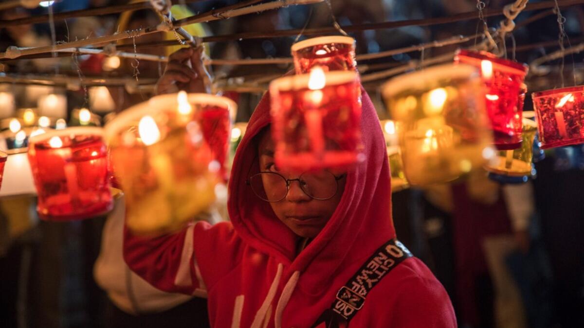 This picture taken on November 4, 2019 shows a participant preparing to release a hot-air balloon during the Tazaungdaing Lighting Festival at Taunggyi in Myanmar's northeastern Shan State. Brightly coloured balloons with hundreds of homemade fireworks woven into their frames are sent soaring into the night sky, showering down cascades of sparks onto adoring crowds in the annual Taunggyi fire balloon festival. SAI AUNG MAIN / AFP