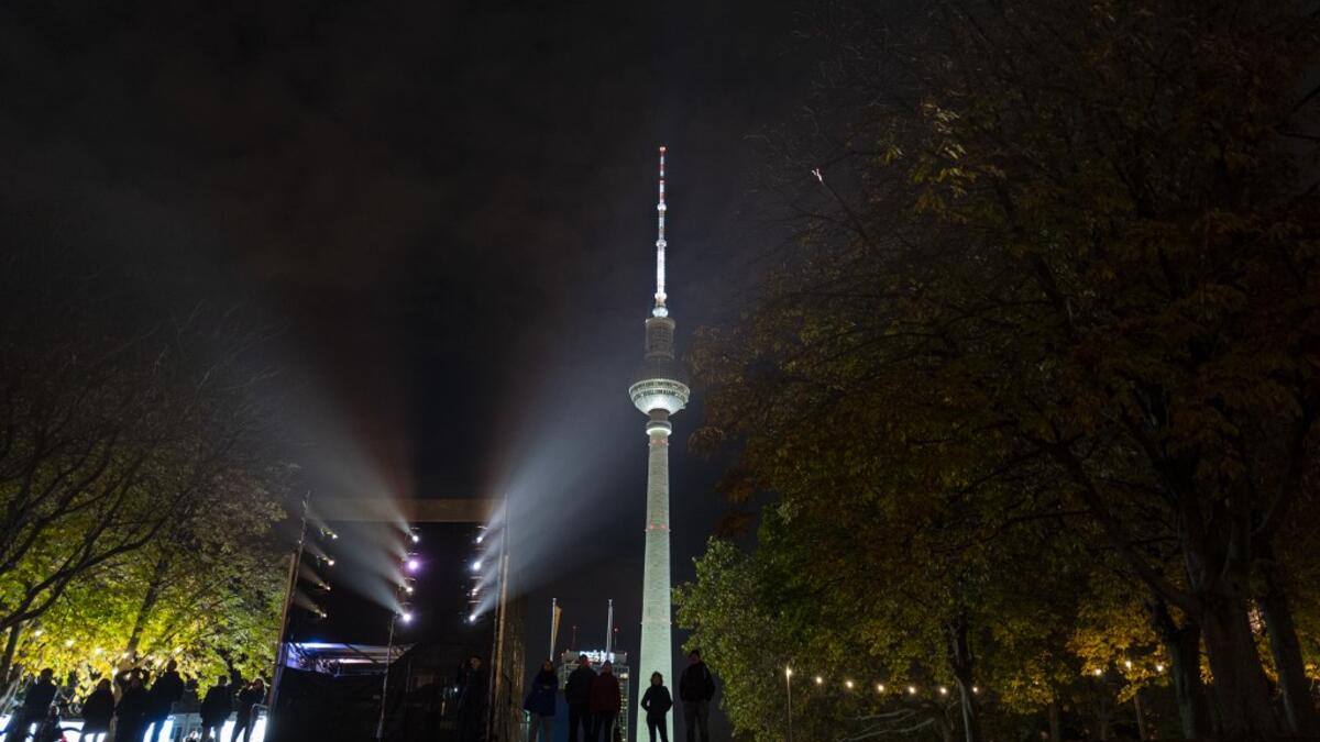 People look at a light show projected onto the Humboldt Forum building as part of the festival week to celebrate the 30th anniversary of the November 9,1989 fall of the Berlin Wall, in Berlin on November 5, 2019. Germany marks three decades since the fall of the Berlin Wall this week with main celebrations on November 9, 2019. John MACDOUGALL / AFP