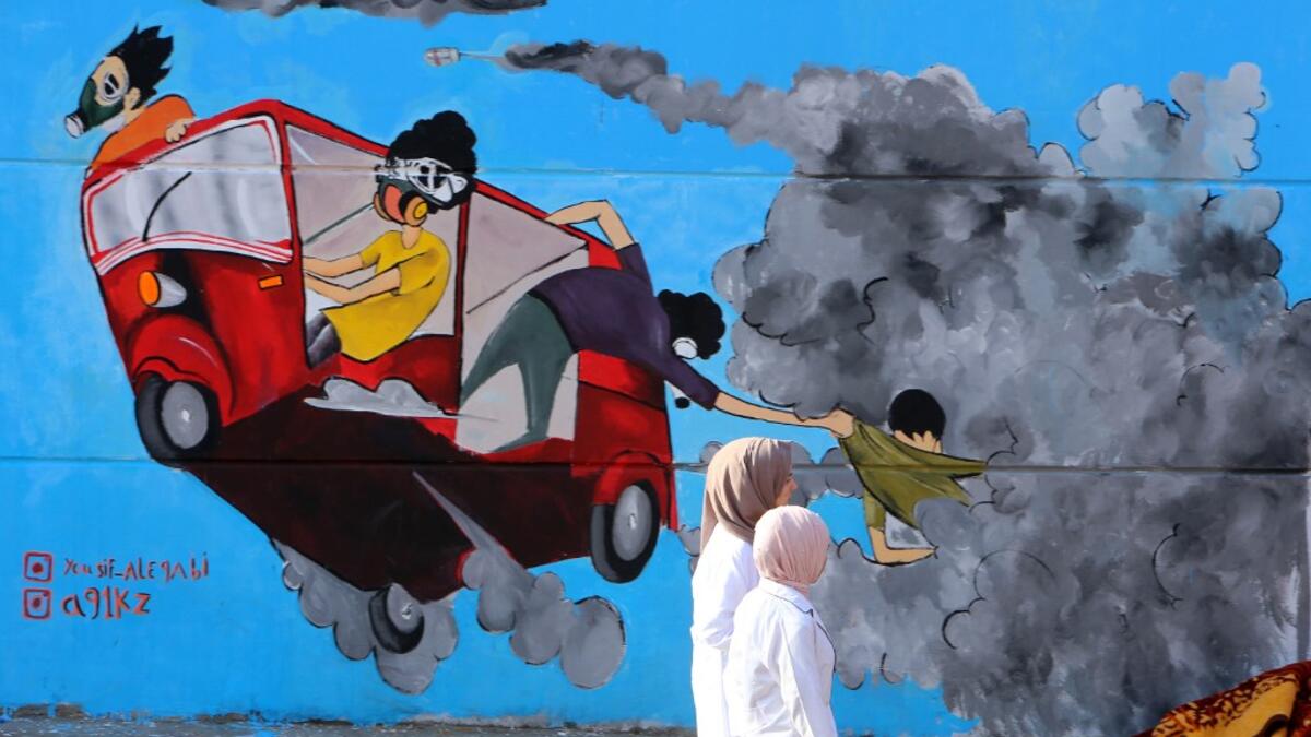 Young Iraqis walk past colourful murals in Baghdad's Tahrir Square as the Iraqi capital braces for another day of anti-government protests on November 6, 2019. A mounting death toll in Baghdad and across southern Iraq coupled with renewed internet restrictions sparked fears that anti-government protests would once again trigger chaos. SABAH ARAR / AFP