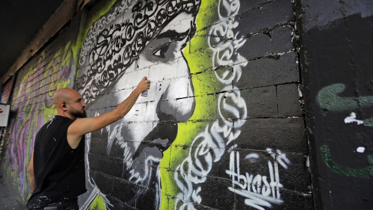 Graffiti artist Mohammad Abrashh draws a graffiti on the wall of a building at the al-Nour Square in the northern port city of Tripoli on November 7, 2019. An unprecedented protest movement has gripped Lebanon since October 17, demanding an overhaul of a political class that has remained largely unchanged since the end of the country's 1975-1990 civil war. In the northern city of Tripoli, where mobilisation has been relentless since the protests erupted on October 17, demonstrators took down politicians' po