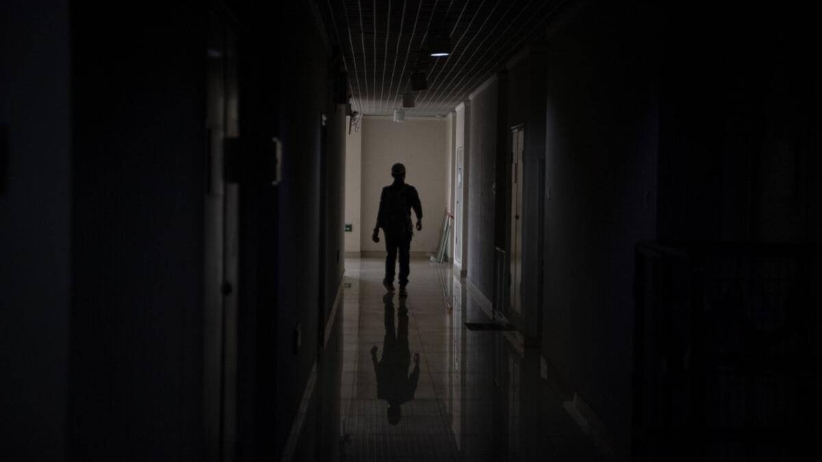 This photo taken on October 23, 2019 shows pet detective Sun Jinrong searching for a missing cat in a residential compound in Beijing. Private sleuth Sun Jinrong brings heat detectors, tiny surveillance cameras, and a blowdart loaded with a tranquiliser to his search for one desperate client's missing loved one: A cat named Duoduo.  NOEL CELIS / AFP