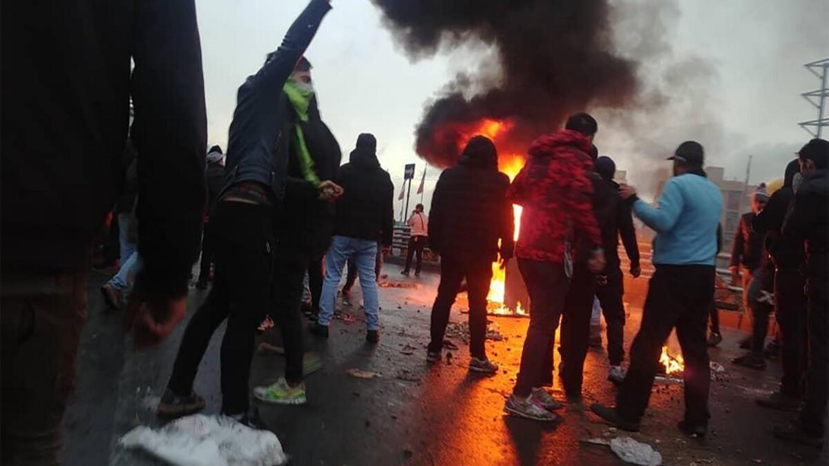 Iranian protesters gather around a fire during a demonstration against an increase in gasoline prices in the capital Tehran, on November 16, 2019. One person was killed and others injured in protests across Iran, hours after a surprise decision to increase petrol prices by 50 percent for the first 60 litres and 300 percent for anything above that each month, and impose rationing. Authorities said the move was aimed at helping needy citizens, and expected to generate 300 trillion rials ($2.55 billion) per an