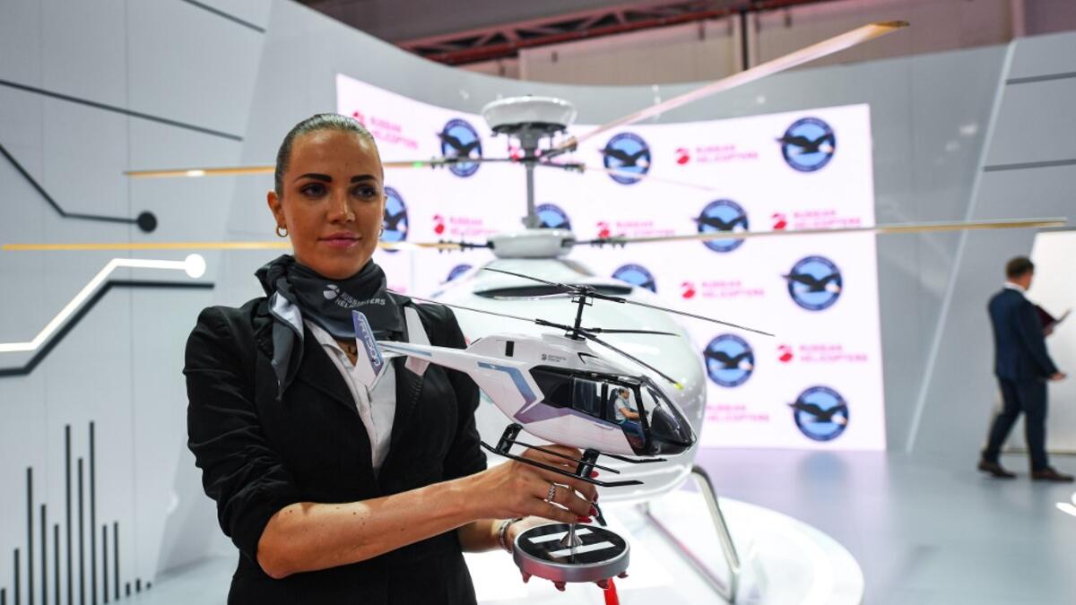 A Russian Helicopters presenter holds a model of a VRT 500 twin coaxial rotor light helicopter at a booth during the 2019 Dubai Airshow on November 18, 2019. KARIM SAHIB / AFP