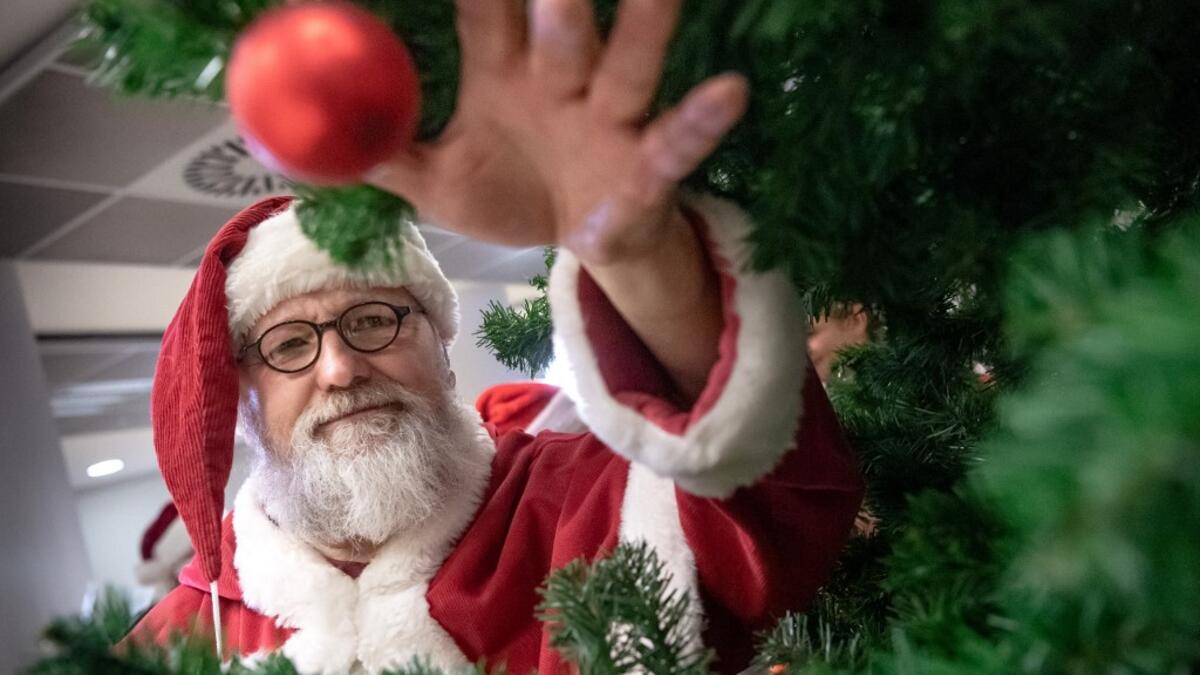 A man dressed as Santa Claus grabs a Christmas ball during an event on November 21, 2019 at the job center in Hanover, northern Germany, where informations were given on how to become a seasonal Christmas helper. Sina Schuldt / DPA / AFP