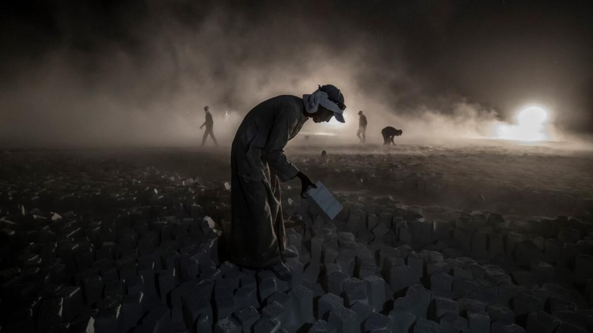 A labourer carries a stone block while working late at the "White Mountain" limestone extraction quarry site near Egypt's southern city of Minya, some 265 kilometres south of the capital, on November 13, 2019. Covered in fine white dust, labourers at the so-called "White Mountain" off Minya toil in shifts amidst brutal conditions with little workplace safety for paltry pay. They handle dangerous machinery with finesse, and shrug off the dangers of a job where a mistake can prove fatal. Khaled DESOUKI / AFP