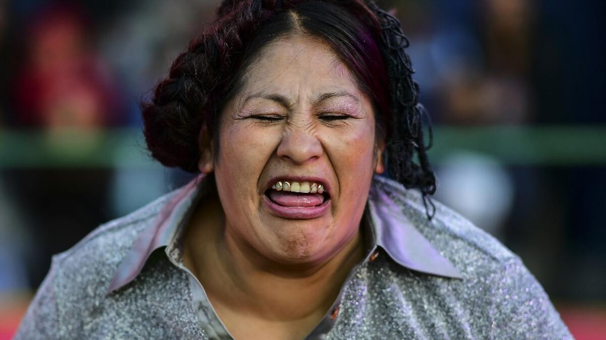 Bolivian wrestler Ana Luisa Yujra, aka "Jhenifer Two Faces", member of the Fighting Cholitas, grimaces during a bout at Sharks of the Ring wrestling club in El Alto, Bolivia, on November 24, 2019. After a fortnight hiatus due to anti-government protests and blockades, the Fighting Cholitas are back in the ring. The unrest was triggered by the disputed October 20 election, which Evo Morales claimed to have won and opposition groups said was rigged. Ronaldo SCHEMIDT / AFP