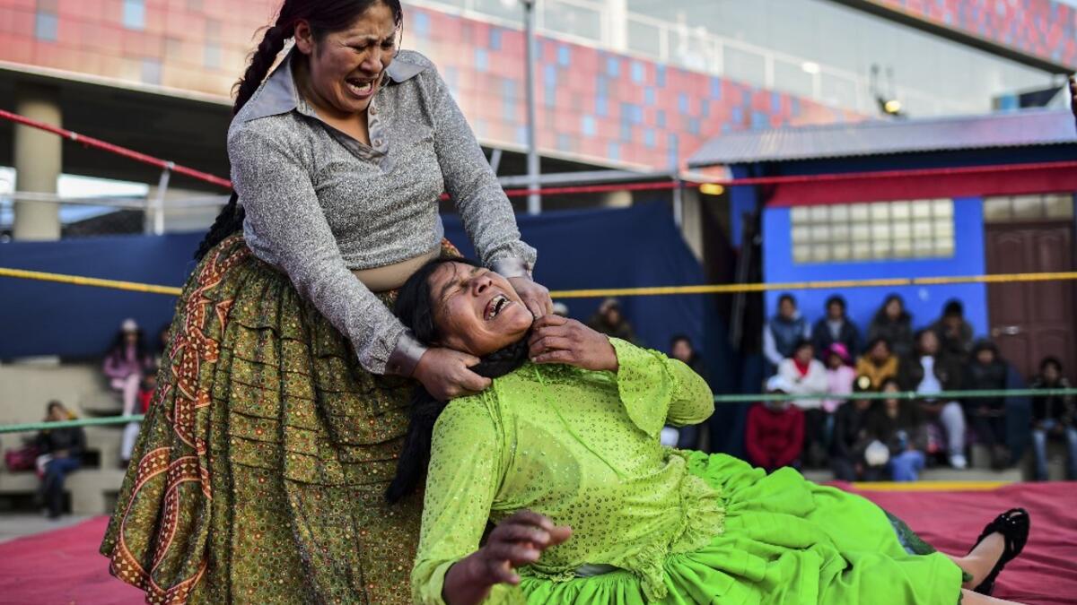 Bolivian wrestler Ana Luisa Yujra (L), aka "Jhenifer Two Faces" and Lidia Flores, aka "Dina, The Queen of the Ring", both members of the Fighting Cholitas, fight at Sharks of the Ring wrestling club in El Alto, Bolivia, on November 24, 2019. After a fortnight hiatus due to anti-government protests and blockades, the Fighting Cholitas are back in the ring. The unrest was triggered by the disputed October 20 election, which Evo Morales claimed to have won and opposition groups said was rigged. Ronaldo SCHEMID