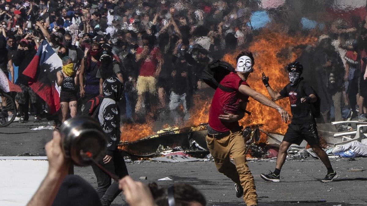 People demonstrate at Plaza Italia on the fifth straight day of street violence which erupted over a now suspended hike in metro ticket prices, in Santiago on October 22, 2019. President Sebastian Pinera convened a meeting with leaders of Chile's political parties on Tuesday in the hope of finding a way to end street violence that has claimed 15 lives, as anti-government campaigners threatened new protests. Pedro UGARTE / AFP