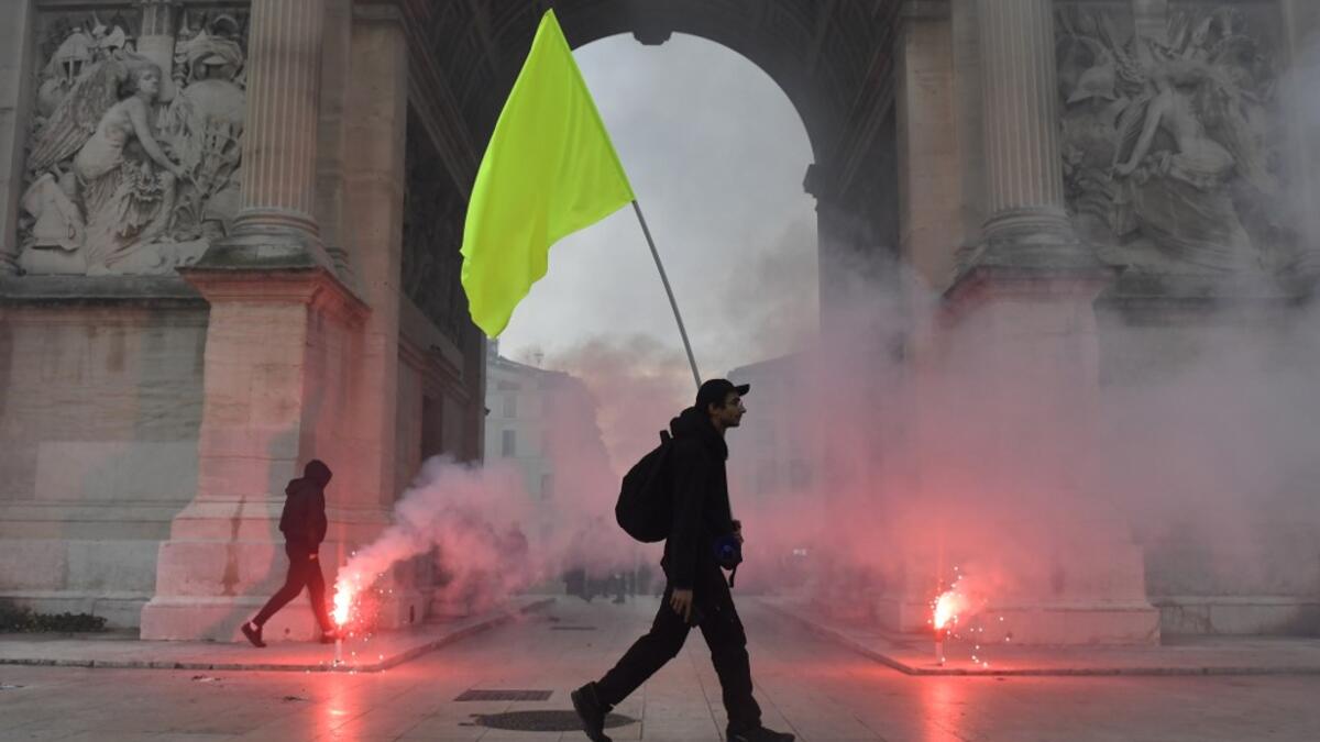 A man holds a yellow flag during a demonstration to protest against the pension overhauls, in Marseille, southern France, on December 5, 2019 as part of a national general strike. Trains cancelled, schools closed: France scrambled to make contingency plans on for a huge strike against pension overhauls that poses one of the biggest challenges yet to French President's sweeping reform drive. CLEMENT MAHOUDEAU / AFP