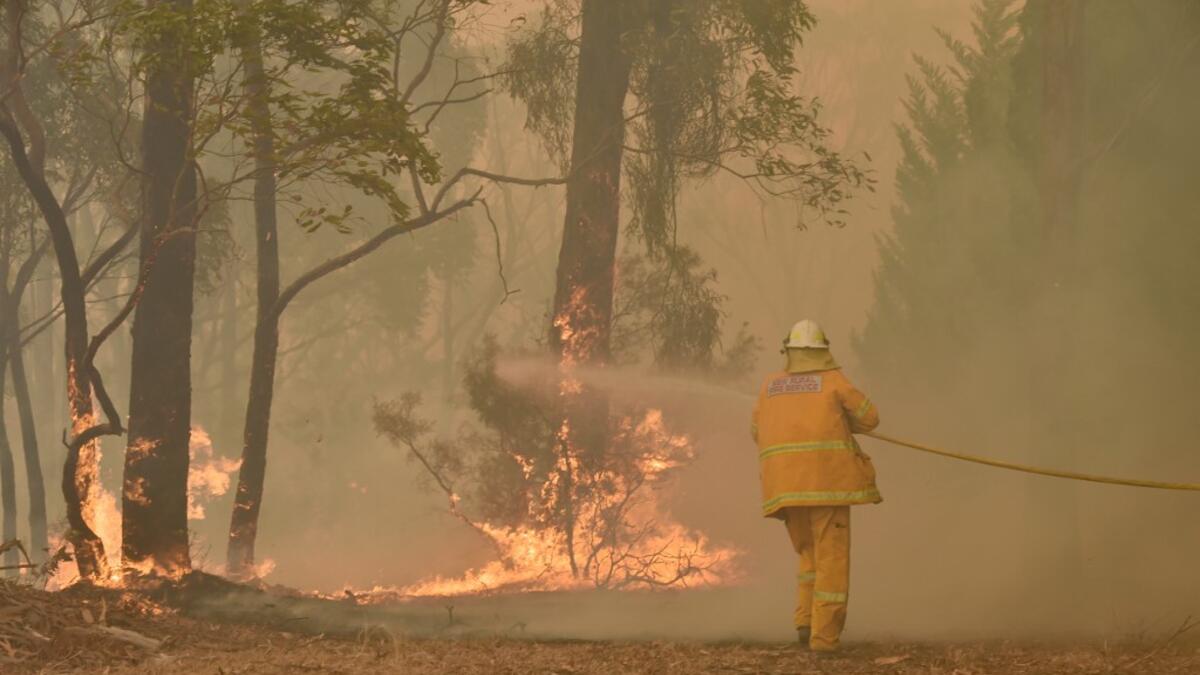 A fireman fights a bushfire to protect a property in Balmoral, 150 kilometres southwest of Sydney on December 19, 2019. A state of emergency was declared in Australia's most populated region on December 19, as a record heat wave fanned unprecedented bushfires. PETER PARKS / AFP
