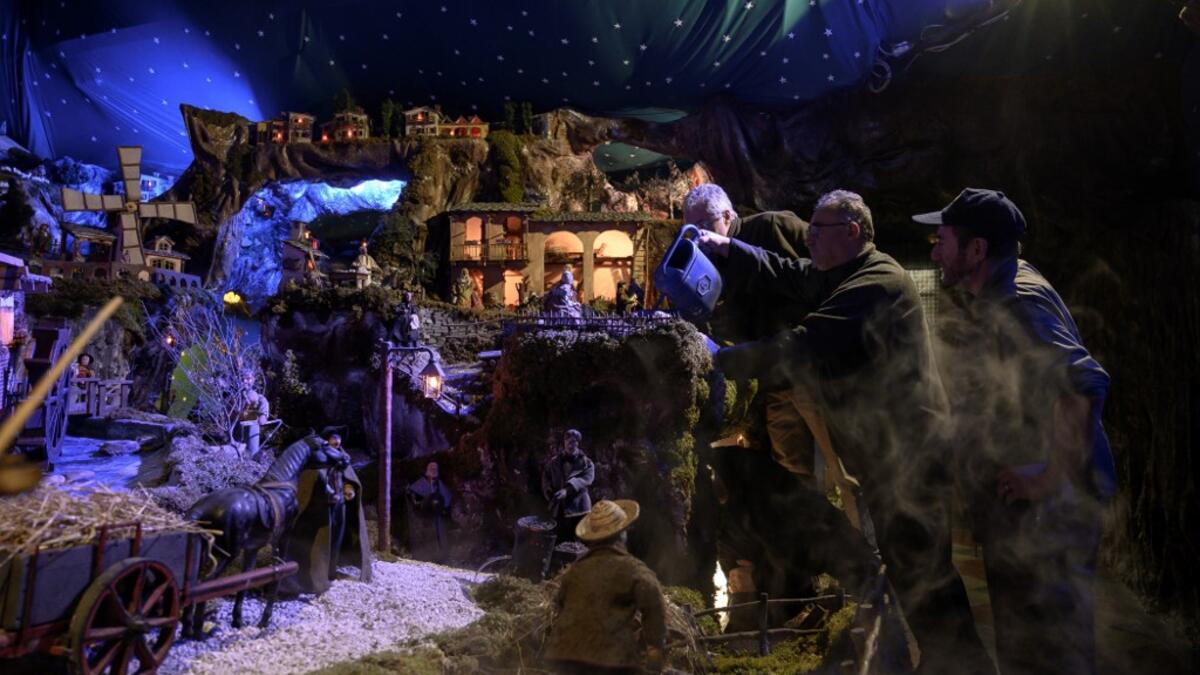 Volunteers set nativity figures at the 43rd edition of the "Presepio of Cavallermaggiore", a 300sqm Christmas Nativity crib in the Oratorio San Michele on December 20, 2019 in Cavallermaggiore, near Cuneo, Northwestern Italy. The "Presepio" is made by ten volunteers who every year spend 3 months to build a new edition with hundred of figures. MARCO BERTORELLO / AFP