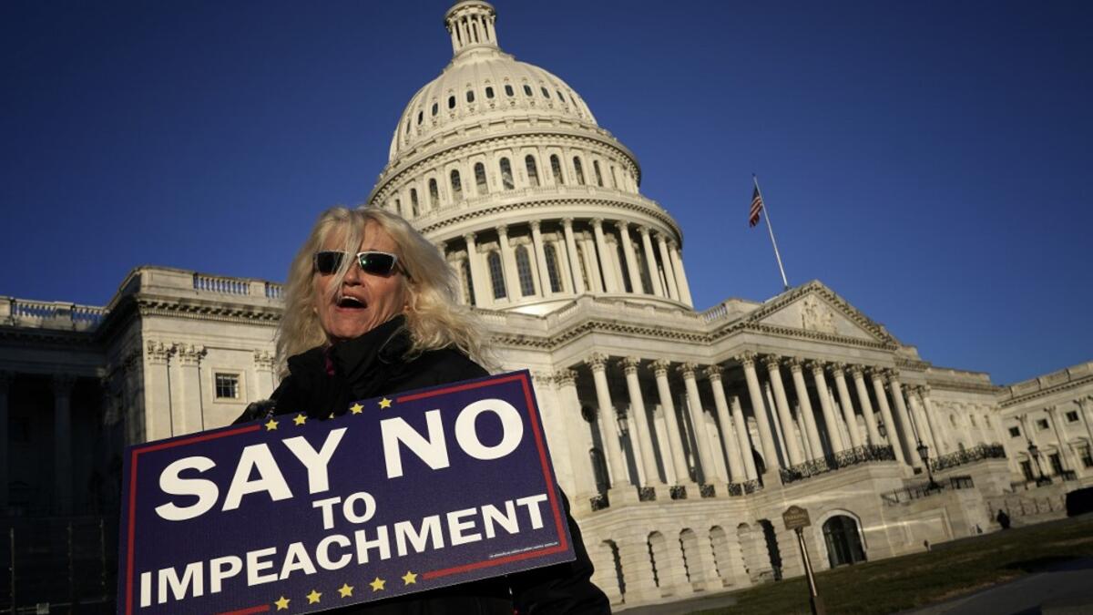 A woman supporting U.S. President Donald Trump walks outside the U.S. Capitol December 18, 2019 in Washington, DC. Later today the U.S. House of Representatives is expected to vote on two articles of impeachment against Trump charging him with abuse of power and obstruction of Congress. Win McNamee/Getty Images/AFP