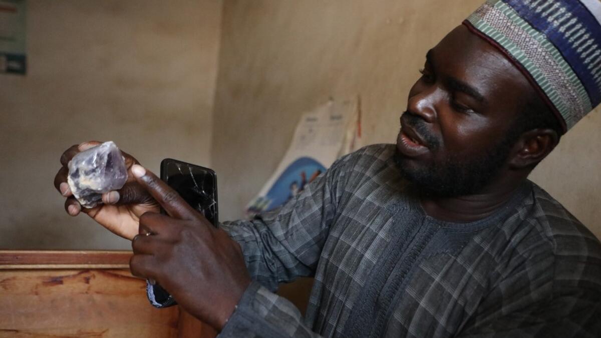 Ayuba Ahmad Muhammed, secretary of the Zamfara State Gold Buyers and Sellers, displays a mined mineral in Gusau, on December 5, 2019. For generations, the mineral-rich earth of Nigeria's Zamfara state has provided families living here with a way to make ends meet. Kola Sulaimon / AFP
