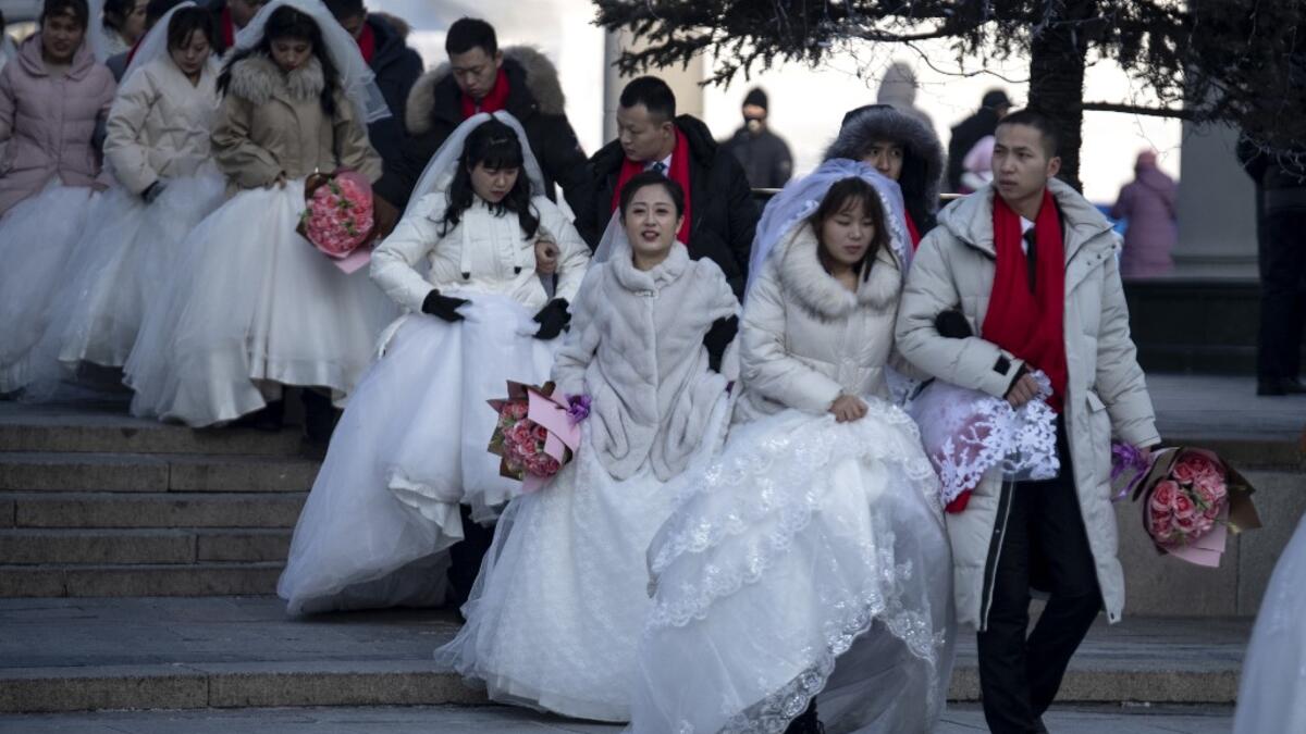 Couples arrive for a "mass ice and snow wedding" ahead of the opening of the Harbin International Ice and Snow Festival in Harbin, in China's northeast Heilongjiang province on January 5, 2020. Noel CELIS / AFP