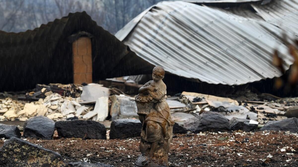 A statue at a burnt house is seen after an overnight bushfire in Quaama in Australia's New South Wales state on January 6, 2020. Reserve troops were deployed to fire-ravaged regions across three Australian states on January 6 after a torrid weekend that turned swathes of land into smouldering, blackened hellscapes. SAEED KHAN / AFP