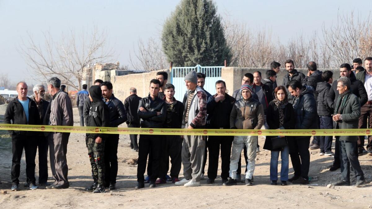 Bystanders watch from a behind a cordon as rescue teams work after a Ukrainian plane carrying 176 passengers crashed near Imam Khomeini airport in the Iranian capital Tehran early in the morning on January 8, 2020, killing everyone on board. The Boeing 737 had left Tehran's international airport bound for Kiev, semi-official news agency ISNA said, adding that 10 ambulances were sent to the crash site. AFP