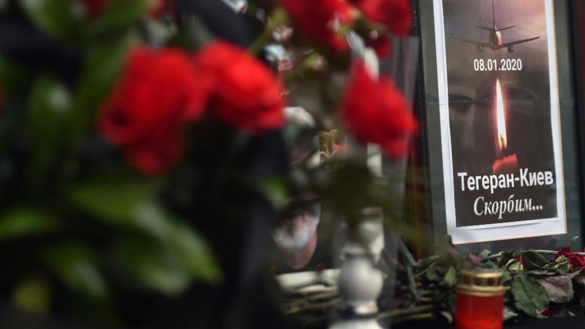 Flowers, candles and a placard reading "Tehran-Kiev We mourn" are seen placed outside the Iranian embassy in Kiev on January 8, 2020, in remembrance of the victims of the Ukraine International Airlines Boeing 737-800 crash in the Iranian capital Tehran. A Ukrainian airliner carrying 176 people from seven countries crashed shortly after takeoff from Tehran on January 8, 2020 killing all on board. The vast majority of the passengers on the Boeing 737, which had been flying from Tehran to Kiev for Ukraine Inte