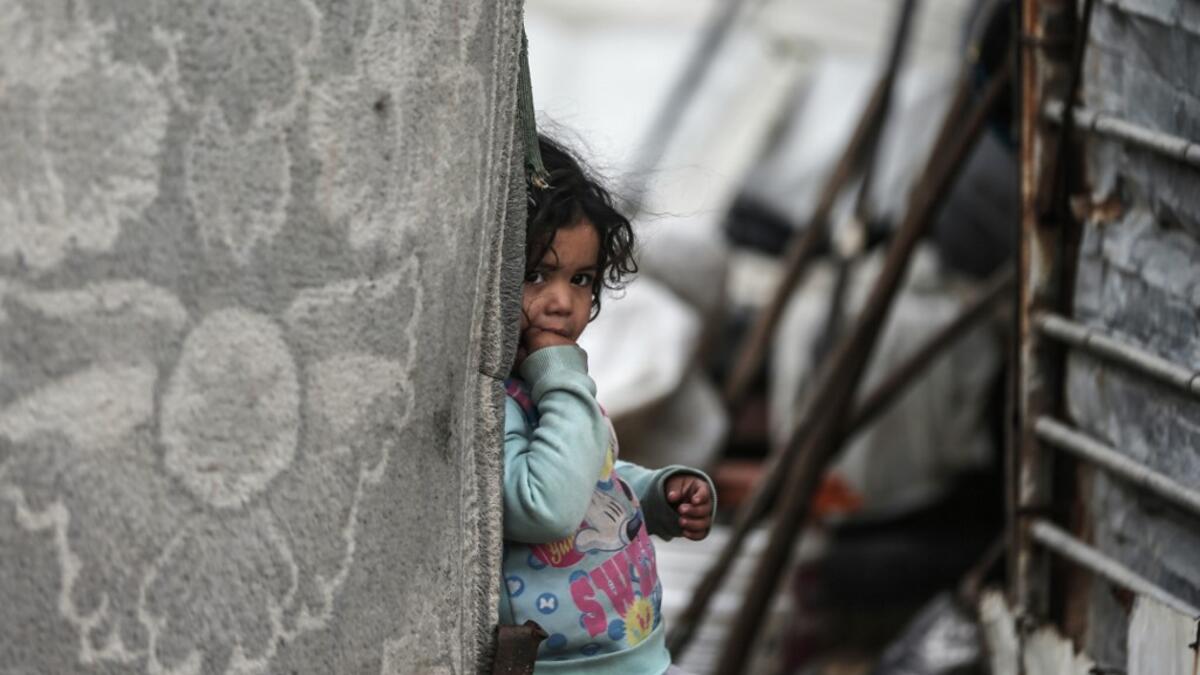 A Palestinian girl pauses as she plays during a cold weather spell in an empoverished neighbourhood on the outskirts in Gaza City on January 9, 2020. MAHMUD HAMS / AFP