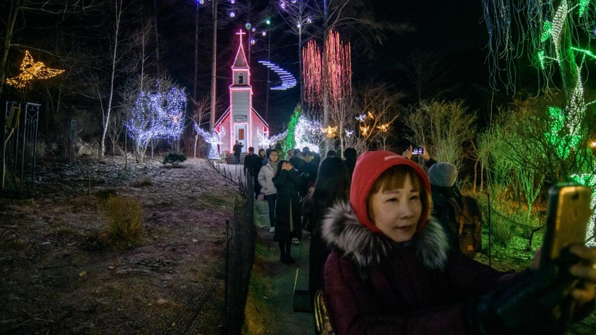 In a photo taken on January 11, 2020 visitors look at an annual light display at the 'Garden on Morning Calm', near Gapyeong, east of Seoul. Ed JONES / AFP