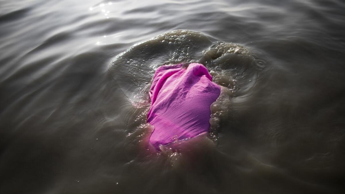 A Hindu devotee takes a holy dip in the Bay of Bengal during the Gangasagar Mela, at Sagar Island, some 150 kilometres south of Kolkata on January 14, 2020. XAVIER GALIANA / AFP