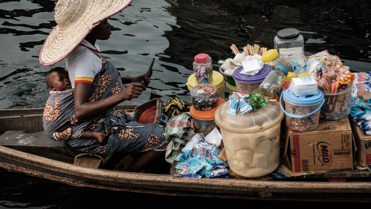 A picture taken on March 2, 2019 shows a woman selling daily items on a boat in the Makoko waterfront community in a polluted lagoon in Lagos, Africa’s biggest megalopolis in Nigeria. The sprawling community began in the 19th century as a fishing village for immigrants who settled on the water's edge. As more arrived and land became rare, people started to move out onto the water. Over time, Makoko became a floating realm of perhaps a quarter of a million people, although the real number is anyone's guess.