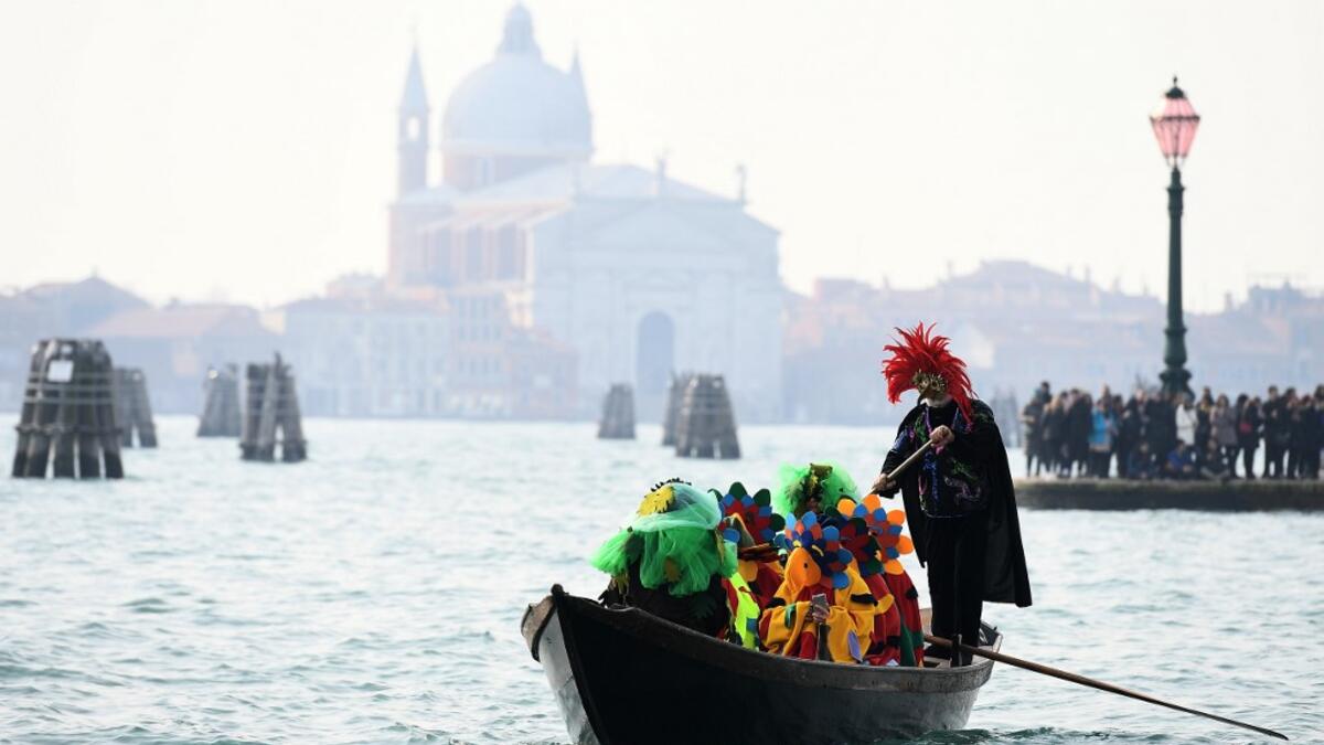 A boat with masked revellers sails on the Grand Canal during the traditional regatta which officially opens the Carnival in Venice, on February 09, 2020. The Venice's carnival takes place until February 25, 2020. Vincenzo PINTO / AFP