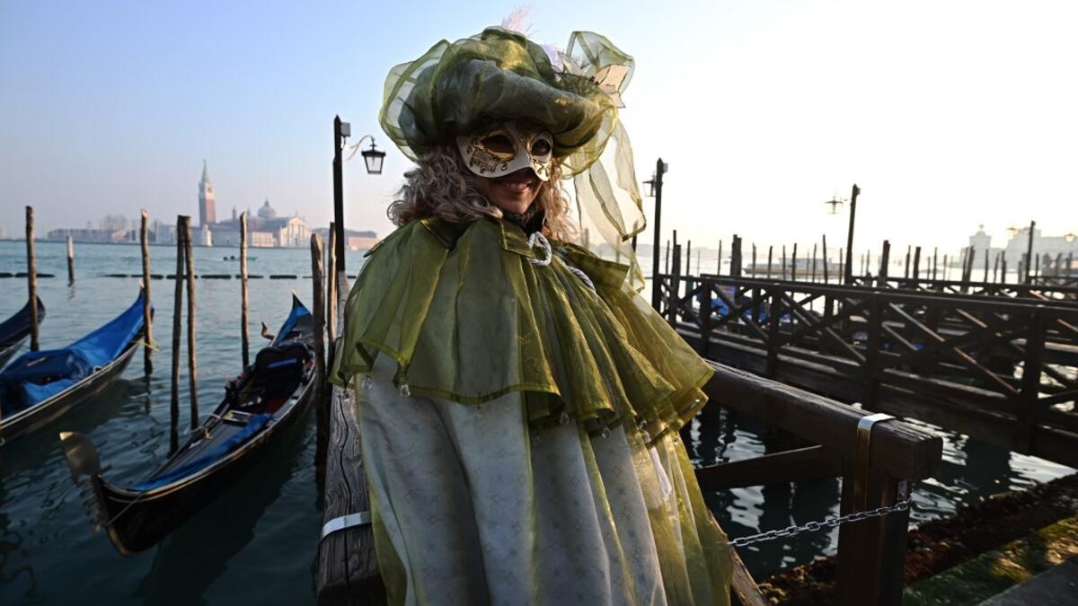 Masked reveller poses in Riva degli Schiavoni during the opening of the Venice Carnival on February 09, 2020. The carnival in Venice takes place until February 25, 2020. Vincenzo PINTO / AFP
