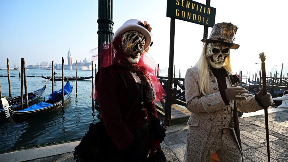 Masked revellers pose in Riva degli Schiavoni during the opening of the Venice Carnival on February 09, 2020. The carnival in Venice takes place until February 25, 2020. Vincenzo PINTO / AFP