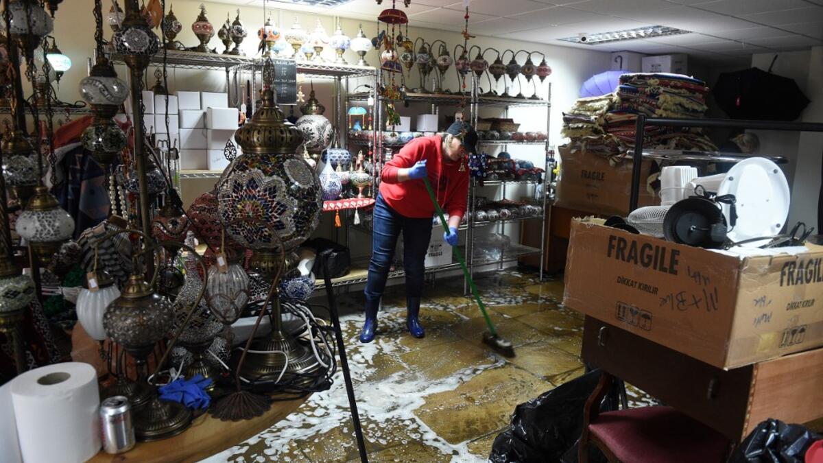 A woman sweeps water from the floor during the clean-up efforts at a business in Hebden Bridge, northern England, on February 10, 2020 after the flooding brought by Storm Ciara. Storm Ciara grounded hundreds of flights Monday and left swatches of Europe without power after unleashing torrential rain and causing flash flooding that cancelled football matches in Britain. Oli SCARFF / AFP