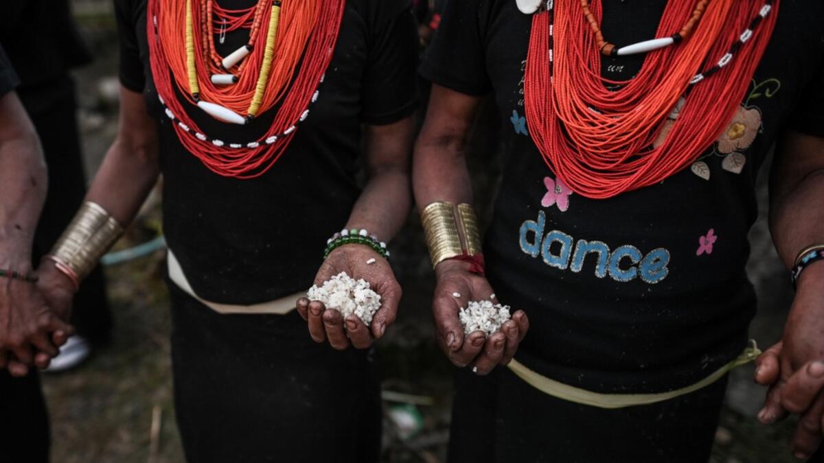 This photo taken on February 7, 2020 shows Naga tribeswomen holding rice at the end of an overnight ceremony to bless the harvest in Satpalaw Shaung village, Lahe township in Myanmar's Sagaing region. A haunting refrain pierces the night as the tribeswomen of the Gongwang Bonyo, among the most isolated people in Myanmar, dance around a campfire to bless the harvest ahead. Ye Aung THU / AFP