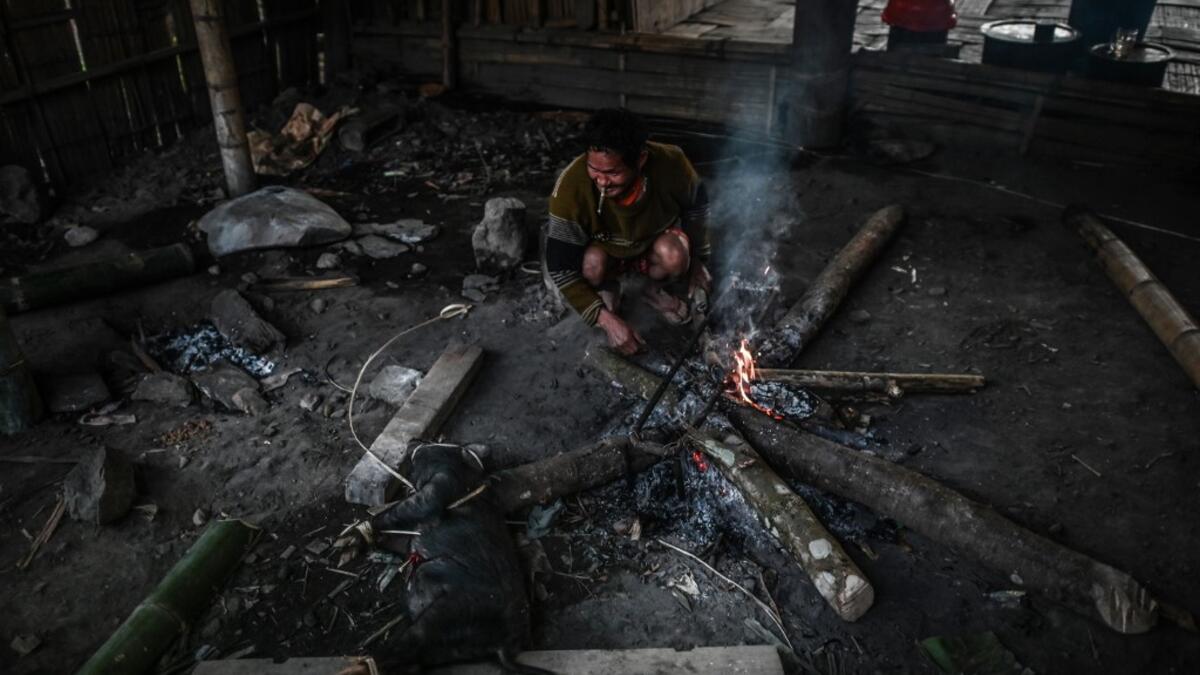 This photo taken on February 7, 2020 shows men preparing a meal after an overnight ceremony by Naga tribeswomen to bless the harvest in Satpalaw Shaung village, Lahe township in Myanmar's Sagaing region. A haunting refrain pierces the night as the tribeswomen of the Gongwang Bonyo, among the most isolated people in Myanmar, dance around a campfire to bless the harvest ahead. Ye Aung THU / AFP