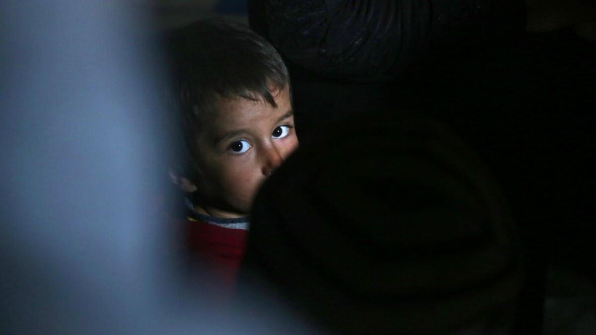 A child looks on as he sits with other members of a family of internally displaced Syrians in an underground shelter where several families from Aleppo and Idlib provinces are taking refuge, in the village of Taltunah about 15 kilometres northwest of Idlib in the northwestern Idlib province, on February 23, 2020. Aref TAMMAWI / AFP