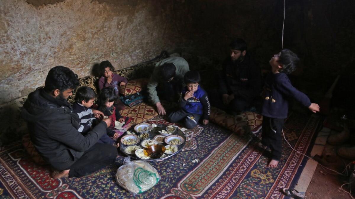 Members of a family of internally displaced Syrians eat together in an underground shelter where several families from Aleppo and Idlib provinces are taking refuge, in the village of Taltunah about 15 kilometres northwest of Idlib in the northwestern Idlib province, on February 23, 2020. Aref TAMMAWI / AFP