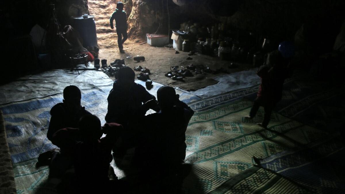 Members of a family of internally displaced Syrians sit together in an underground shelter where several families from Aleppo and Idlib provinces are taking refuge, in the village of Taltunah about 15 kilometres northwest of Idlib in the northwestern Idlib province, on February 23, 2020. Aref TAMMAWI / AFP