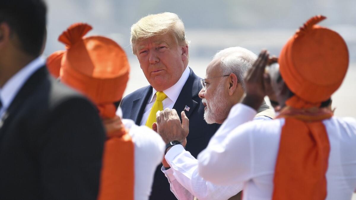 India's Prime Minister Narendra Modi (R) speaks with US President Donald Trump (C) upon his arrival at Sardar Vallabhbhai Patel International Airport in Ahmedabad on February 24, 2020. MANDEL NGAN / AFP