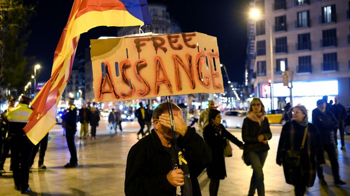 A demonstrator covers his face as he takes part in a protest called by Catalan National Assembly (ANC) under the motto "Journalism is not a crime" to support WikiLeaks founder Julian Assange in Barcelona on February 24, 2020. A British court today starts hearing Washington's extradition request for WikiLeaks founder Julian Assange in a test case of media freedoms in the digital age and the global limits of US justice. LLUIS GENE / AFP