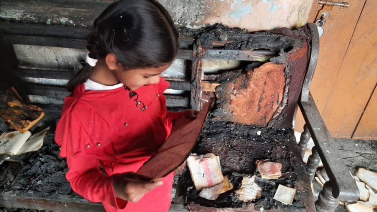 6 year old girl, Aaisha still finds her notebook to read from the debris of the house that was burnt in Monday violence in Chandbagh and Bhajanpura area of northeast Delhi. (Twitter)