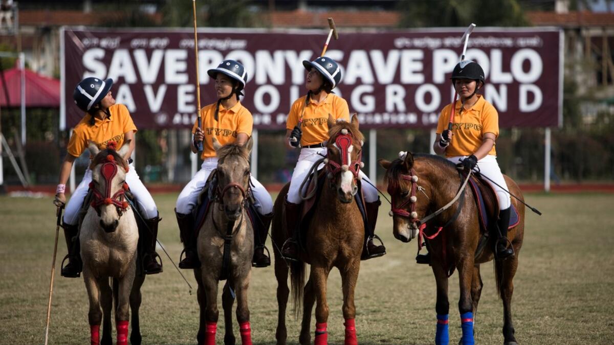 In this photograph taken on January 7, 2020, Thangmeiband Youth Polo Club players line up before their match against Linthoingambi Kangjei Lup polo club during the 15th Women's State Polo Tournament at the Mapal Kangjeibung (Polo Ground) in Imphal, the capital of the northeastern Indian state of Manipur. Laishram Thadoi's face is a picture of concentration as she adjusts her helmet and prepares to play in Manipur, the remote Indian state regarded as the birthplace of modern polo. Xavier GALIANA / AFP