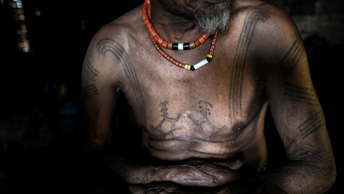 This photo taken on February 6, 2020 shows Ngon Pok, 80, a tattooed Lainong tribesman, at his house at Lahel township in Sagaing region of Myanmar, wedged in a semi-autonomous zone near the Indian border. People in the region subscribe to a complex patchwork of customs, intertwining their animist beliefs with warrior traditions that include striking tattoo designs, which can signify tribal identity, life accomplishments or the completion of a rite of passage. Ye Aung THU / AFP