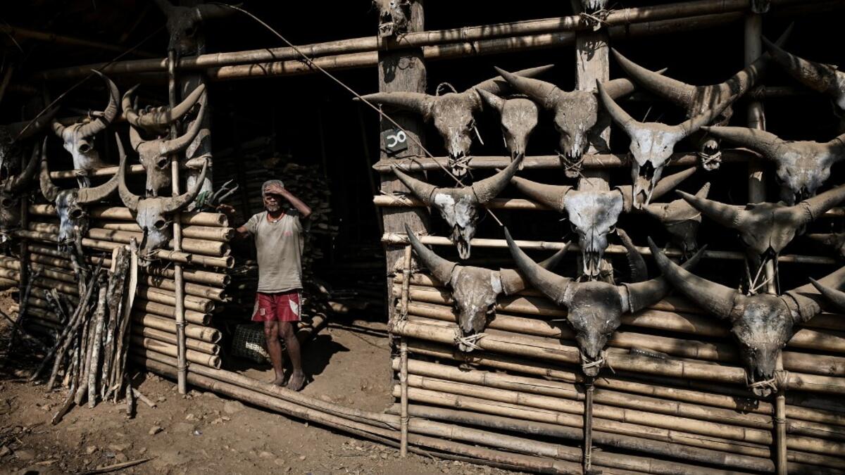 This photo taken on February 5, 2020 shows a Naga tribesman standing in front of his house decorated with skeletons of buffalo heads in Lahel township in Sagaing region of Myanmar, wedged in a semi-autonomous zone near the Indian border. People in the region subscribe to a complex patchwork of customs, intertwining their animist beliefs with warrior traditions that include striking tattoo designs, which can signify tribal identity, life accomplishments or the completion of a rite of passage. Ye Aung THU / A