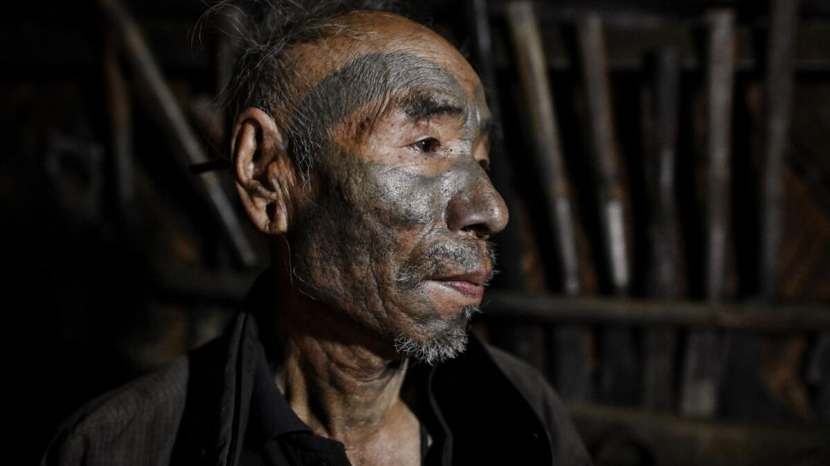 This photo taken on February 9, 2020 shows Nok Tan, 75, a tattooed Konyak tribeman, in his house in a village in Sagaing region of Myanmar, wedged in a semi-autonomous zone near the Indian border. People in the region subscribe to a complex patchwork of customs, intertwining their animist beliefs with warrior traditions that include striking tattoo designs, which can signify tribal identity, life accomplishments or the completion of a rite of passage. Ye Aung THU / AFP