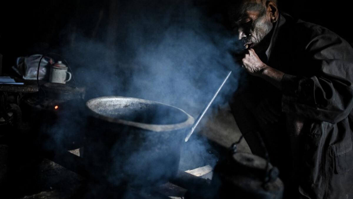 This photo taken on February 9, 2020 shows Nok Tan, 75, a tattooed Konyak tribeman, cooking in his house in a village in Sagaing region of Myanmar, wedged in a semi-autonomous zone near the Indian border. People in the region subscribe to a complex patchwork of customs, intertwining their animist beliefs with warrior traditions that include striking tattoo designs, which can signify tribal identity, life accomplishments or the completion of a rite of passage. Ye Aung THU / AFP