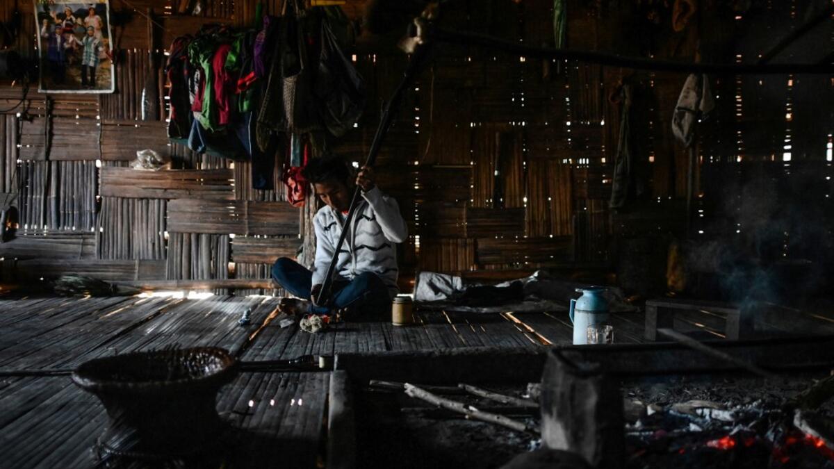 This photo taken on February 4, 2020 shows a Naga tribesman checking an old hunting rifle at his home at a village in Sagaing region of Myanmar, wedged in a semi-autonomous zone near the Indian border. People in the region subscribe to a complex patchwork of customs, intertwining their animist beliefs with warrior traditions that include striking tattoo designs, which can signify tribal identity, life accomplishments or the completion of a rite of passage. Ye Aung THU / AFP